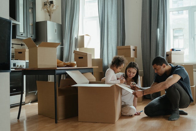 couple with child opening boxes in kitchen